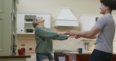 Happy Couple Dancing in Modern Home Kitchen