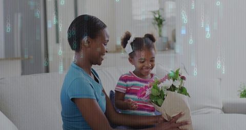 Mother giving bouquet to smiling daughter on sofa with green binary tech overlay