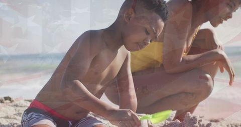 Mother and son playing on beach with shovel
