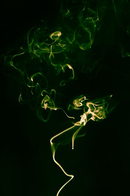 This visual of swirling green smoke against a black background is perfect for creating a mysterious or ethereal ambiance. Ideal for backgrounds in graphic design, posters, websites, and creative projects where an abstract or mystical theme is desired.
