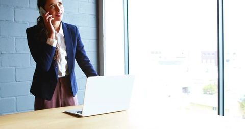 Confident Businesswoman Discussing on Phone in Bright Office