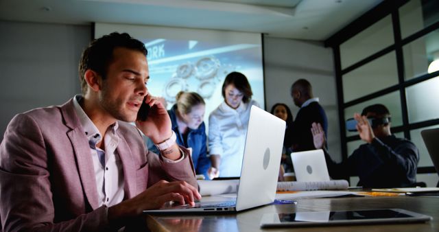 Busy Businessman Talking on Phone in Modern Office During Team Meeting - Download Free Stock Images Pikwizard.com