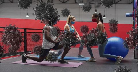 Masked fitness partners lunging in gym performing pandemic workout with virus overlay