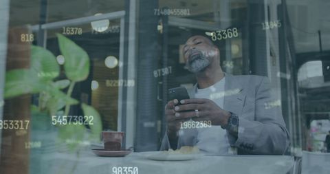 Senior Man Relaxing with Smartphone in Cafe Amidst Digital Data