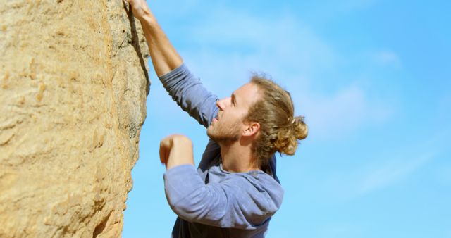 Young Man Rock Climbing Against Blue Sky - Download Free Stock Images Pikwizard.com