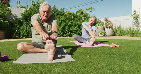 Senior Couple Practicing Yoga and Stretching Outdoors