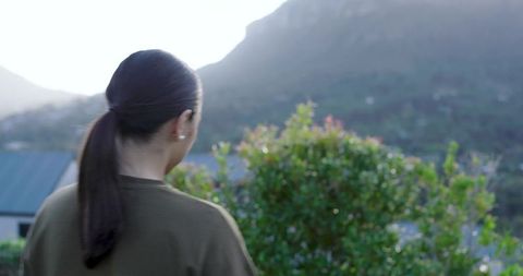 Woman facing mountains embracing tranquil nature setting