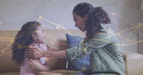 Mother comforting daughter on sofa with network overlay representing emotional connection