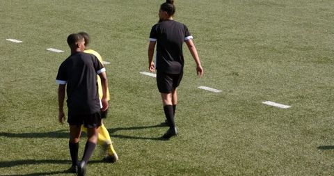 Teen soccer players practicing on open grass field
