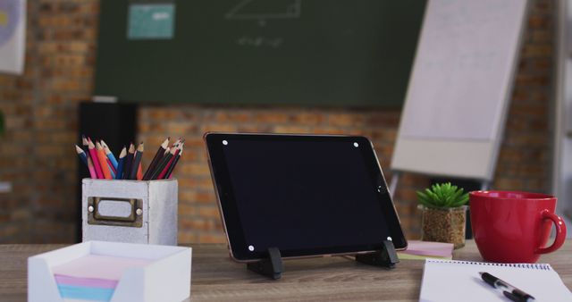 View of digital tablet and other school supplies on table in the classroom at school. distance learning online education