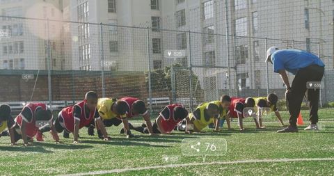Youth soccer team training with coach on urban field