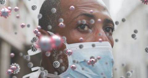 Man wearing face mask surrounded by virus cells concept image