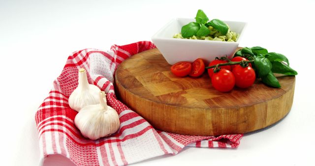 Cherry tomatoes and bowl of pasta with garlic on chopping board - Download Free Stock Photos Pikwizard.com