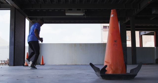 Man Training in Urban Parking Garage with Orange Traffic Cones - Download Free Stock Images Pikwizard.com