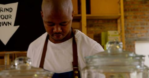 Barista Arranging Coffee Shop Display with Brew Jars