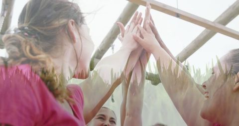 Women Team High-Fiving Under Obstacles During Outdoor Fitness Event