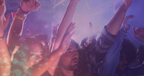 Energetic Crowd Celebrating Concert Experience under Colorful Lights