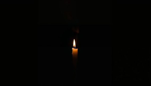 Solitary Candle Burning in Dark for Meditative Reflection