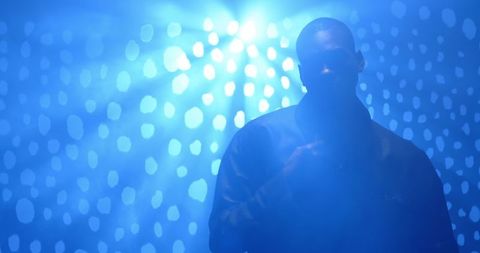 Silhouette of performer under dramatic blue lighting