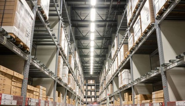 High-capacity warehouse aisle with tall steel racking, palletized inventory, led lighting