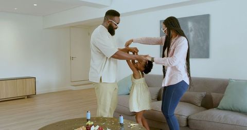 Happy Family Dancing Together in Living Room Celebration