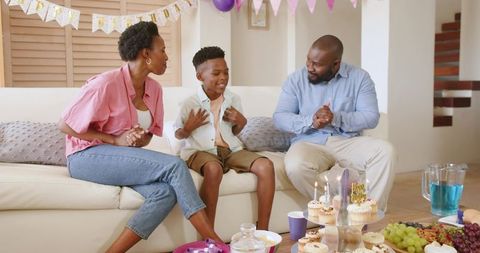 African American Family Celebrating Birthday at Home with Cupcakes, Balloons, and Candles