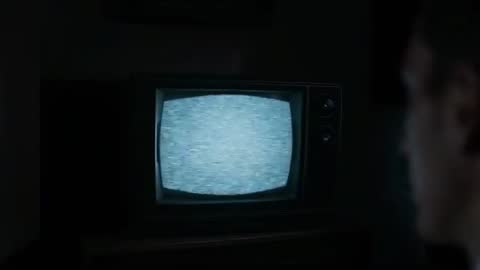 Man Watching Static on Old Console TV in Dim Room