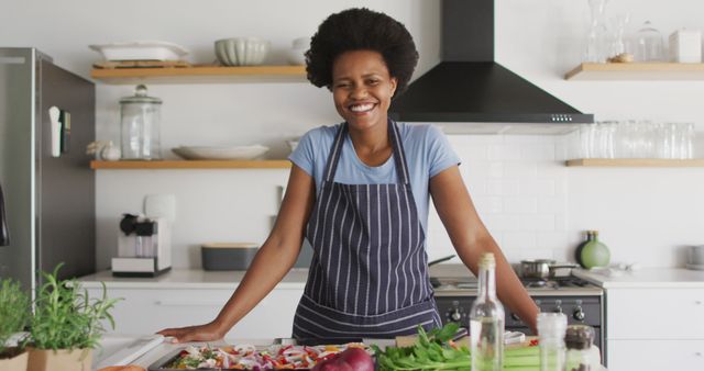 Portrait of happy african american woman preparing dinner in kitchen - Download Free Stock Photos Pikwizard.com