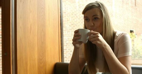Caucasian Businesswoman Enjoying Coffee in Modern Cafe Setting