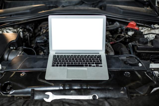 Laptop on a car engine in repair garage