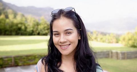 Smiling Woman with Sunglasses Relaxing in Sunny Park