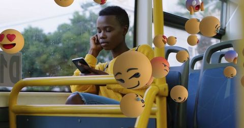 Thoughtful woman using smartphone on bus amid floating emojis
