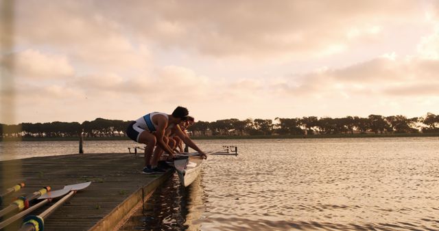 Rowing Team Launching Boat on Calm Lake at Sunset - Download Free Stock Images Pikwizard.com