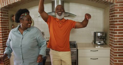 Happy Senior Couple Dancing in Kitchen with Joyful Energy