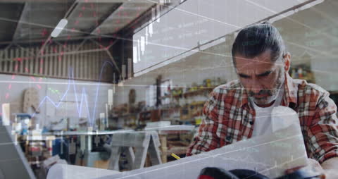 Businessman Analyzing Data in Busy Workshop