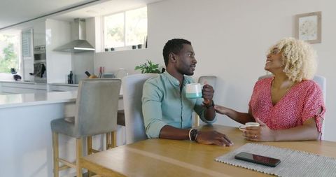 Couple Enjoying Coffee in Modern Kitchen with Smartphone
