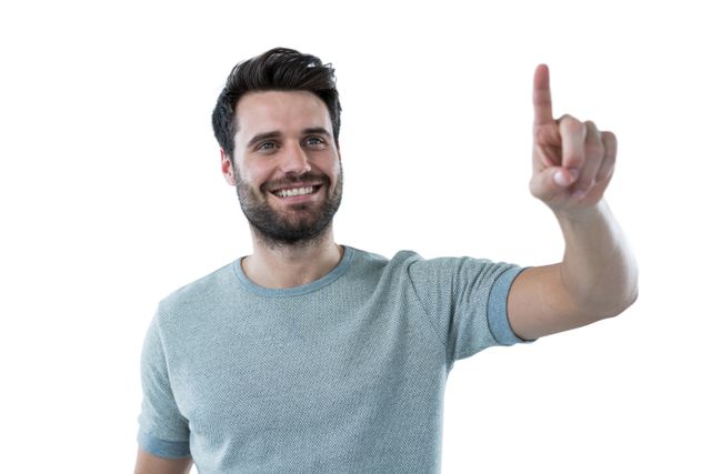 Smiling man pretending to touch an invisible screen against white background