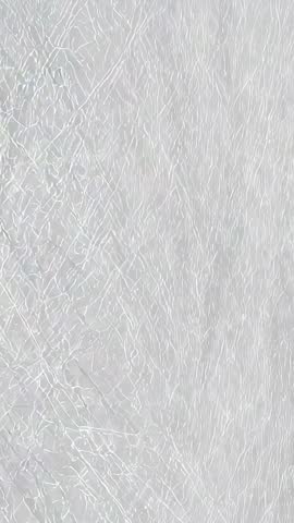 Vertical Macro Video Showing Light Gray Fibrous Texture with Shimmering Thread Patterns