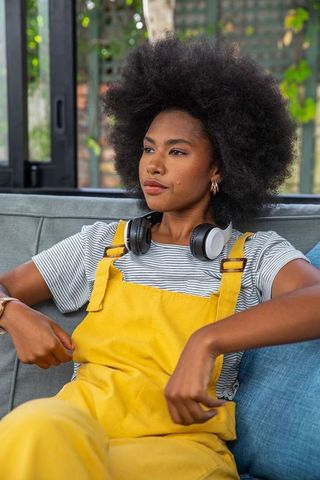 Woman Relaxing on Sofa with Headphones at Home