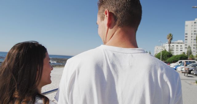 Smiling Young Couple Enjoying Beach Walk Under Clear Blue Sky - Download Free Stock Images Pikwizard.com