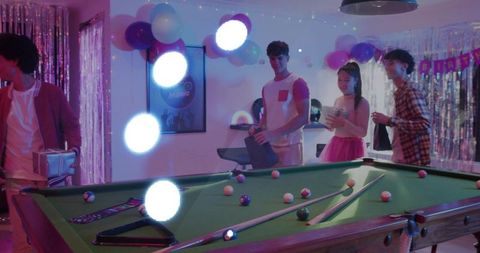 Vibrant birthday game night with pool table, balloons and young friends socializing