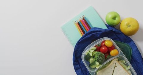 Healthy packed lunch with veggies and fruit in schoolbag