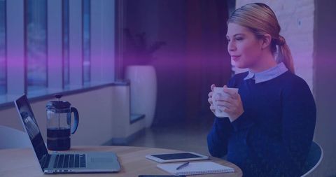 Holding mug and working on laptop in modern coworking space with calm minimalist design