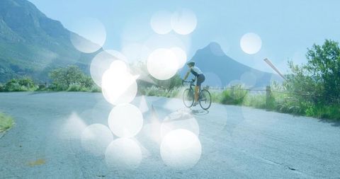 Cyclist Biking on Mountain Road with Enthralling Light Reflections