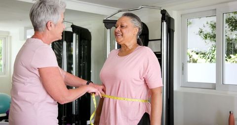 Senior Couple Measuring Waist During Home Workout for Fitness Goals