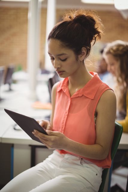 Schoolgirl using digital tablet in classroom, focusing on screen. Ideal for educational content, technology in education, modern learning environments, and student-focused materials.
