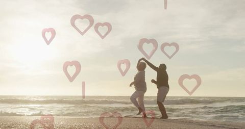 Senior Couple Dancing on Beach at Sunset with Heart Overlays