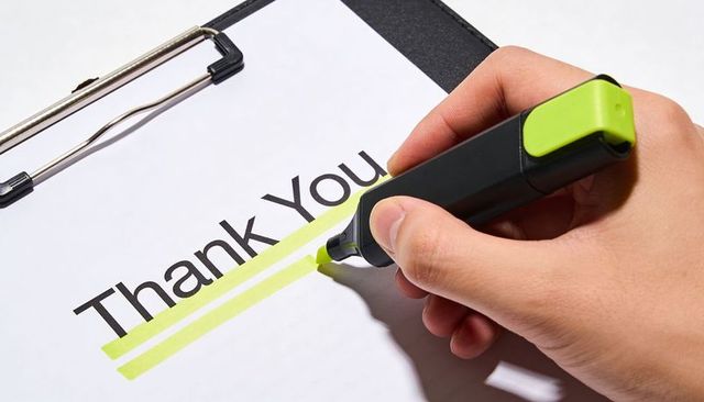 Right Hand Highlighting Thank You on Clipboard Underlining Gratitude with Lime Highlighter