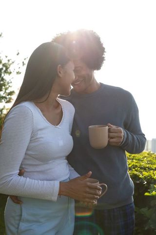 Romantic Couple Embracing on Balcony in Morning Sunlight