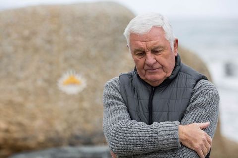 Senior Man in Deep Thought by Coastal Boulder